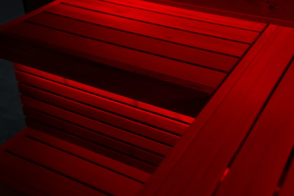 Red-lit cedar benches inside the Genesis